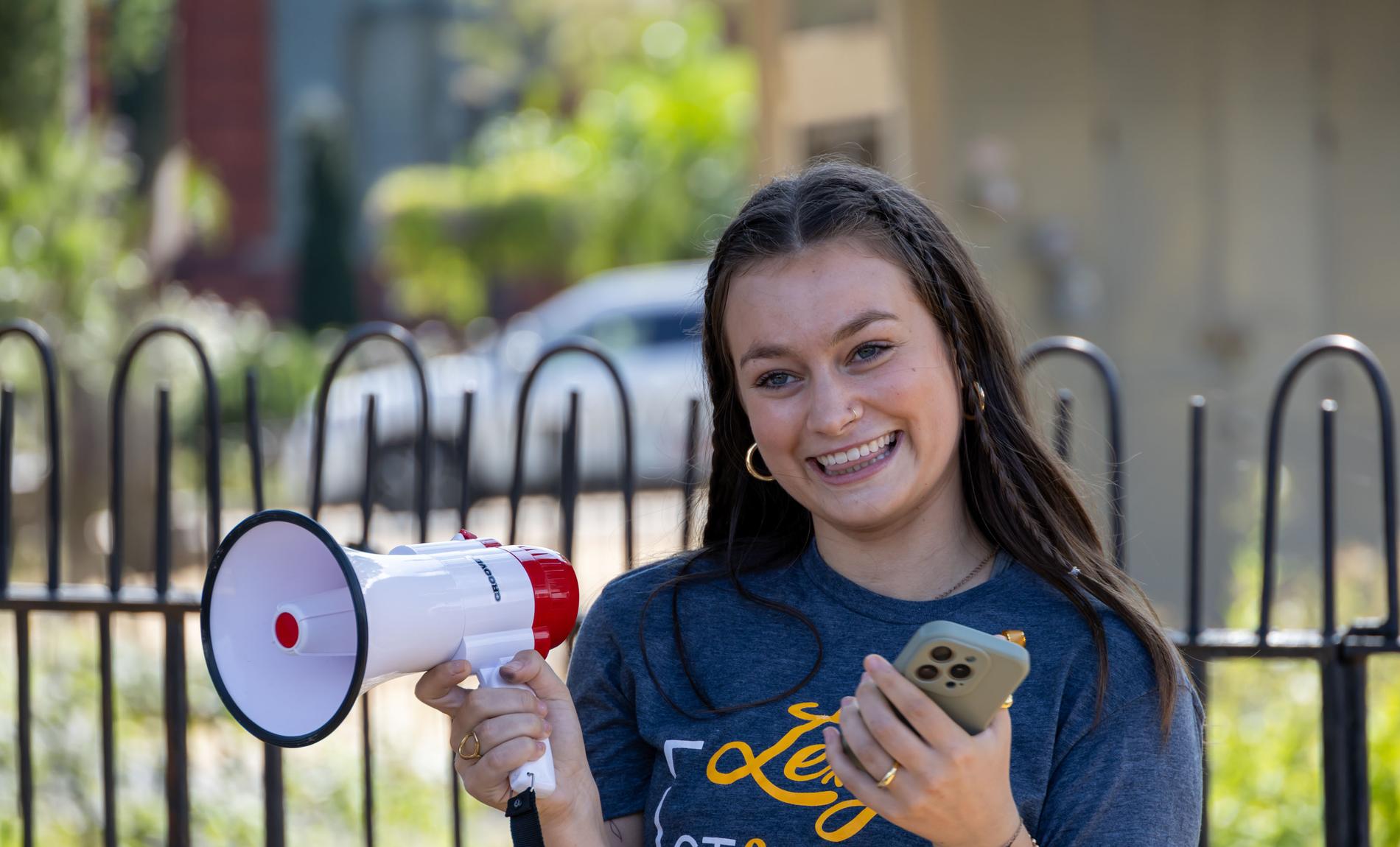 Rally Kid Faith holding a megaphone at an advocacy event