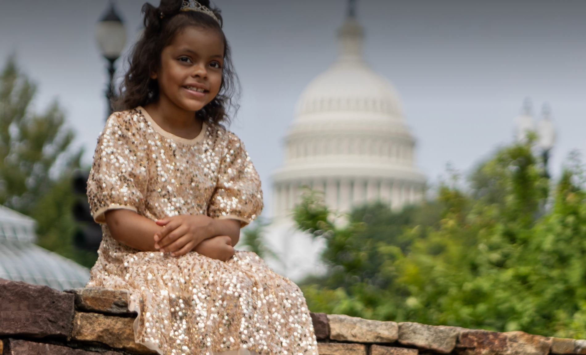 Rally Kid Ailani sitting on a wall in front of the U.S. Capitol