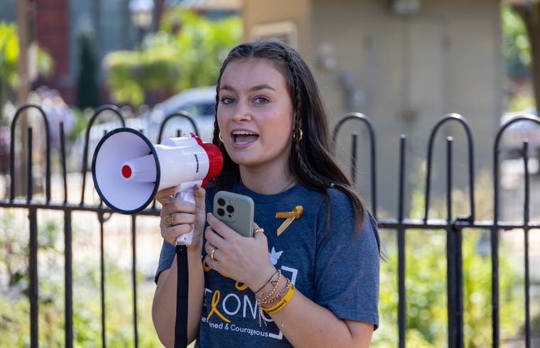 A young advocate speaking into a megaphone at a Rally event
