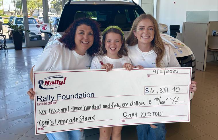 A Rally Kid and her family holding an oversized check for $6,351.40 from a lemonade stand fundraiser