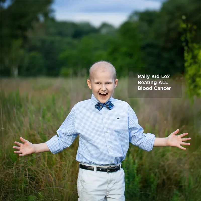 Rally Kid Lex, beating ALL blood cancer, with arms outstretched in a field